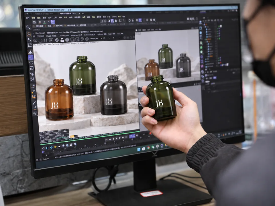 Studio designer holding a green glass bottle sample in front of its 3D render on screen.