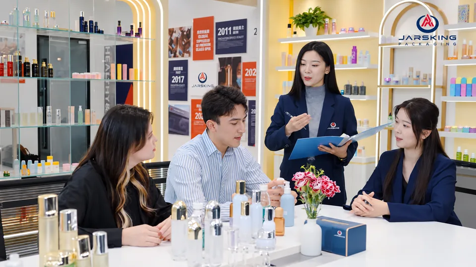 Jarsking Studio team in a working session with brand clients at a table of glass bottle and jar samples in the Jarsking showroom.